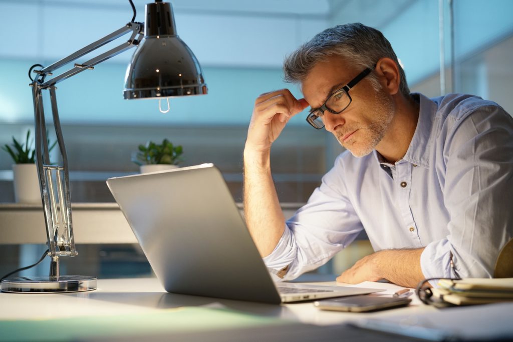 Homme devant ordinateur pour reconversion professionnelle