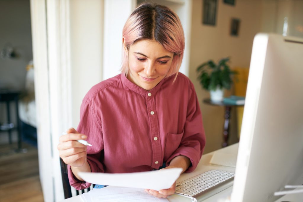 Femme devant ordinateur élaborant un dossier de reconversion professionnelle